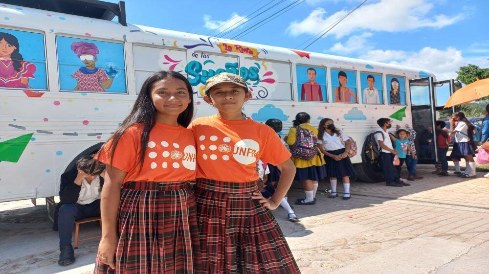 Dos Niñas posan con la Ruta de los Sueños detrás